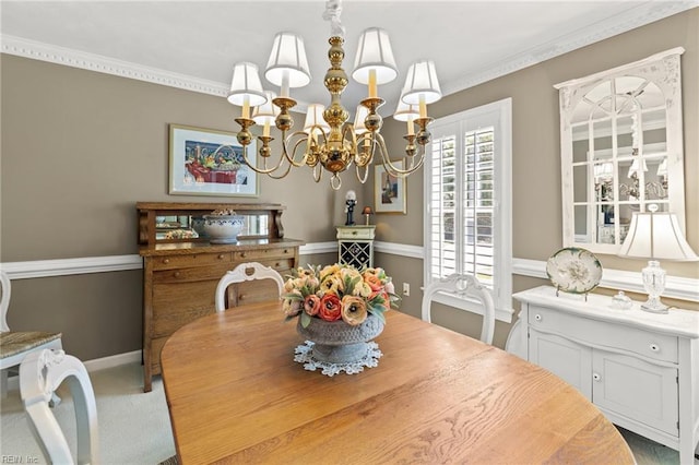dining space with a chandelier, ornamental molding, carpet flooring, and baseboards