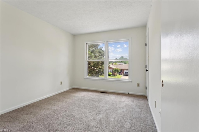 unfurnished room featuring carpet flooring, baseboards, and a textured ceiling
