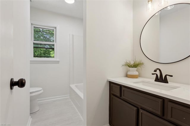 full bathroom featuring vanity, toilet, and baseboards