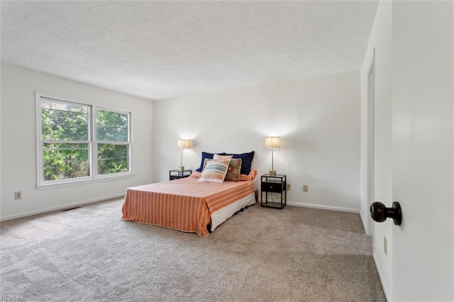 carpeted bedroom featuring a textured ceiling and baseboards