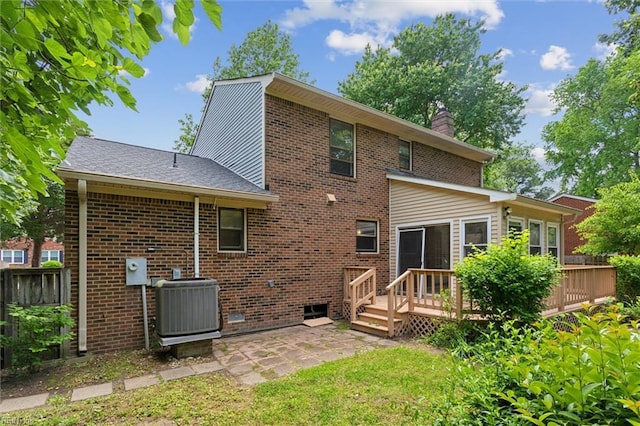 back of property with central AC unit, a wooden deck, and brick siding