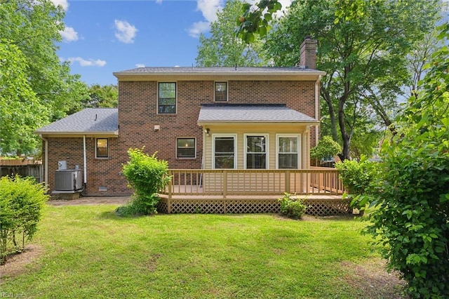 back of house featuring a chimney, central AC unit, a yard, and a deck