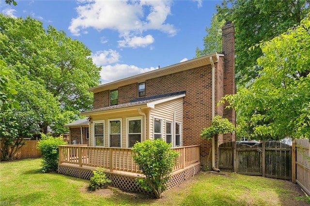 back of house featuring a chimney, a wooden deck, brick siding, and a gate