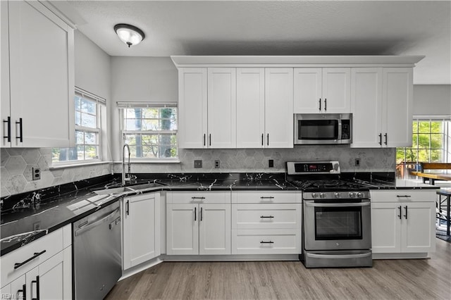 6738 Burbage Landing Cir, Suffolk, VA 23435 - kitchen featuring appliances with stainless steel finishes, a sink, light wood-style flooring, and white cabinets