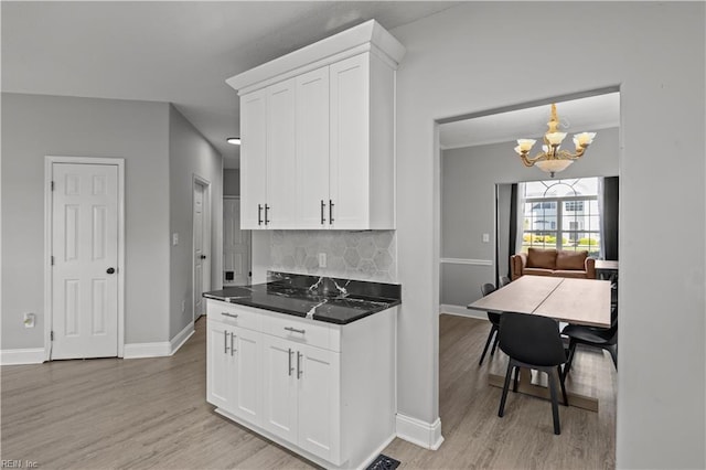 6738 Burbage Landing Cir, Suffolk, VA 23435 - kitchen with light wood finished floors, a chandelier, decorative backsplash, white cabinetry, and baseboards