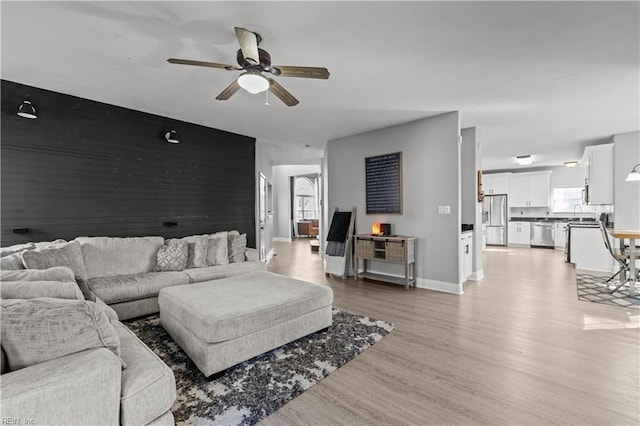 6738 Burbage Landing Cir, Suffolk, VA 23435 - living area with a ceiling fan, light wood-style floors, baseboards, and an accent wall