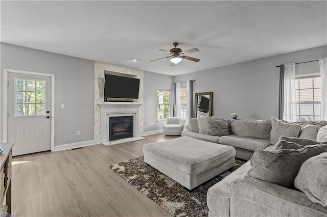 6738 Burbage Landing Cir, Suffolk, VA 23435 - living area with healthy amount of natural light, light wood-type flooring, a ceiling fan, and a large fireplace