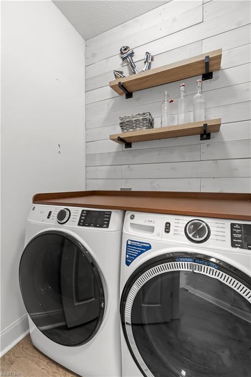 6738 Burbage Landing Cir, Suffolk, VA 23435 - laundry room featuring washer and clothes dryer, wood walls, and light wood-style floors