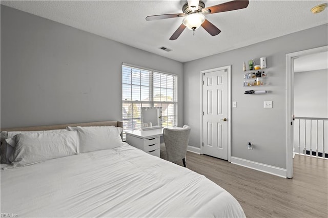 6738 Burbage Landing Cir, Suffolk, VA 23435 - bedroom with wood finished floors, baseboards, ceiling fan, and a textured ceiling