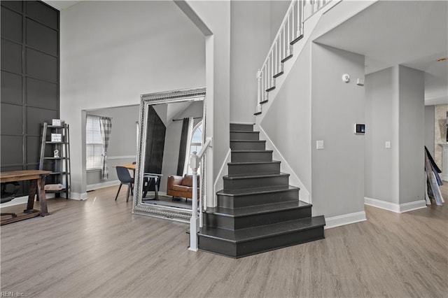 6738 Burbage Landing Cir, Suffolk, VA 23435 - staircase with wood finished floors, a high ceiling, baseboards, and arched walkways