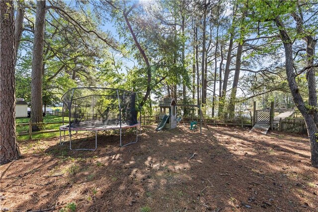6738 Burbage Landing Cir, Suffolk, VA 23435 - view of yard featuring a trampoline, fence, and a playground