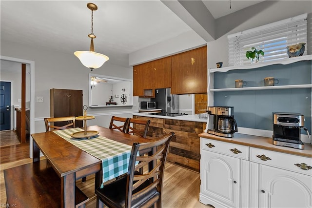 3412 Winterhawk Ct, Chesapeake, VA 23323 - kitchen featuring brown cabinets, light wood-type flooring, black electric stovetop, stainless steel microwave, and light countertops