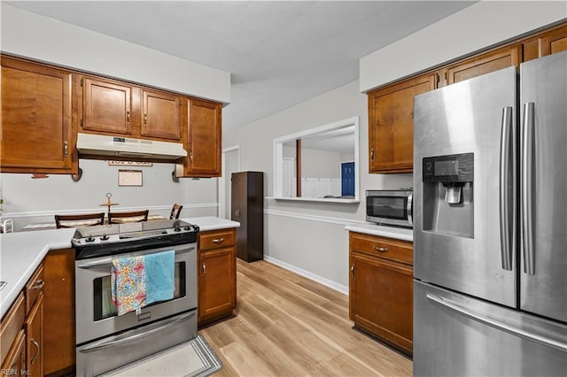 3412 Winterhawk Ct, Chesapeake, VA 23323 - kitchen featuring appliances with stainless steel finishes, under cabinet range hood, light countertops, brown cabinetry, and light wood-type flooring