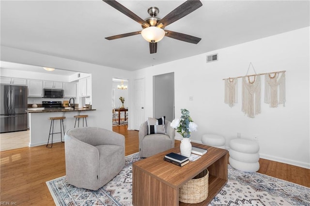 3669 Purebred Dr, Virginia Beach, VA 23453 - living room featuring ceiling fan, a chandelier, light wood finished floors, and baseboards