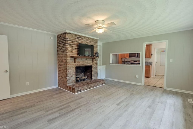 100 Woodland Cir, Franklin, VA 23851 - unfurnished living room featuring light wood-style floors, ceiling fan, a fireplace, ornamental molding, and a sink