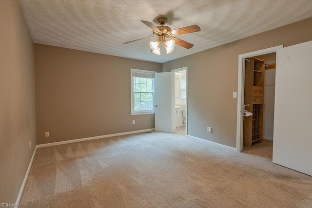 100 Woodland Cir, Franklin, VA 23851 - unfurnished bedroom with a spacious closet, carpet, ensuite bathroom, baseboards, and a textured ceiling