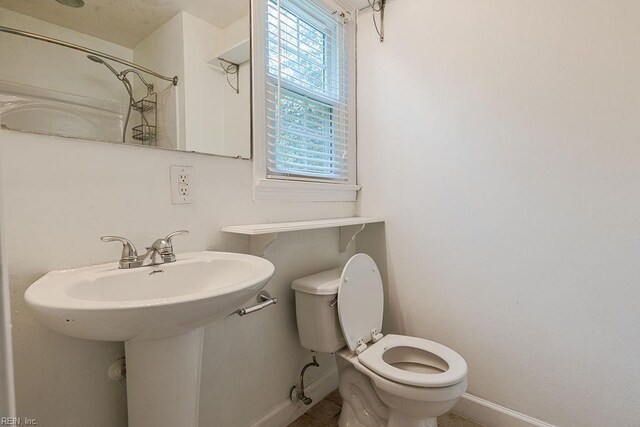 100 Woodland Cir, Franklin, VA 23851 - bathroom featuring toilet, baseboards, a sink, and a shower