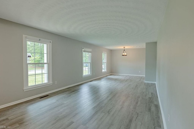 100 Woodland Cir, Franklin, VA 23851 - empty room featuring baseboards, wood finished floors, a textured ceiling, and a chandelier