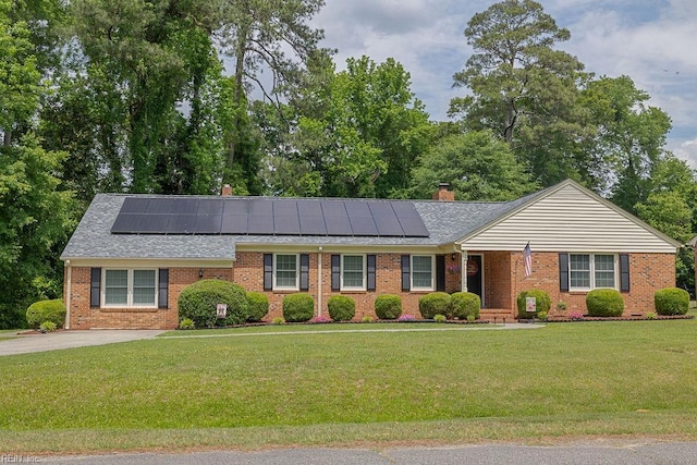 ranch-style house with solar panels, a front lawn, and brick siding