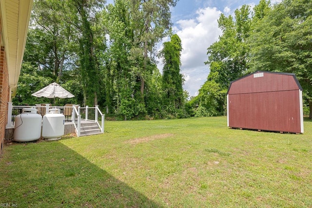 view of grassy yard featuring a storage unit, an outdoor structure, and a wooden deck