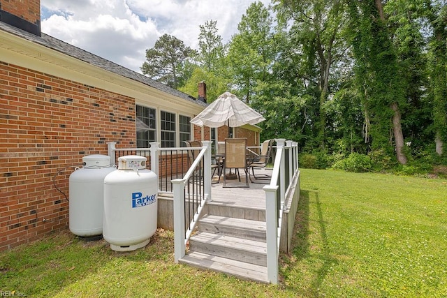 deck with outdoor dining area and a lawn