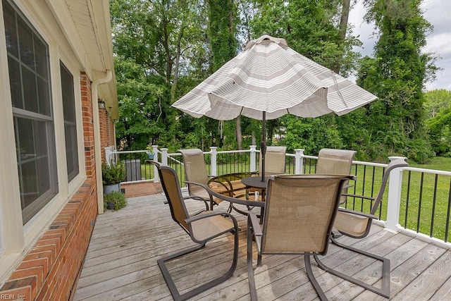 deck featuring outdoor dining area and a yard