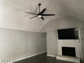 unfurnished living room with lofted ceiling, ceiling fan, baseboards, and a fireplace with raised hearth