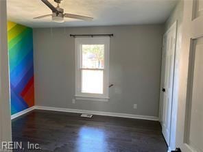 spare room featuring a ceiling fan, wood finished floors, and baseboards