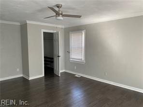 unfurnished bedroom with ornamental molding, wood finished floors, baseboards, and ceiling fan