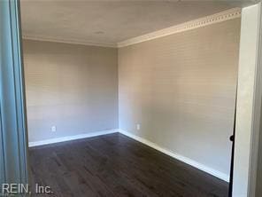 empty room featuring baseboards, dark wood finished floors, and ornamental molding