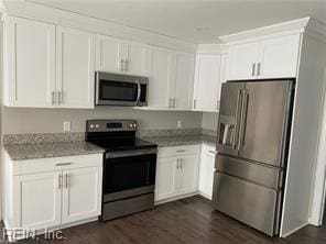 kitchen with appliances with stainless steel finishes, white cabinetry, dark wood-style floors, and light stone counters