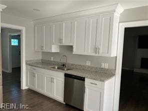 kitchen with dishwasher, a sink, dark wood finished floors, and white cabinetry
