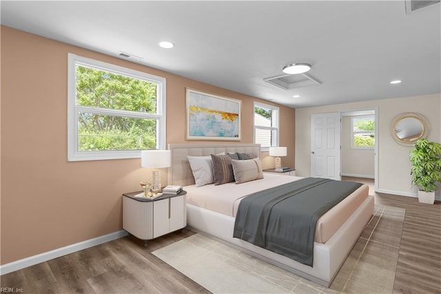 bedroom with baseboards, wood finished floors, and recessed lighting