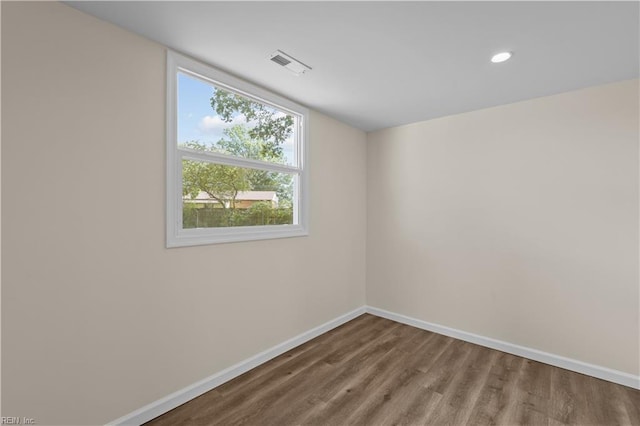 spare room with plenty of natural light, baseboards, wood finished floors, and recessed lighting
