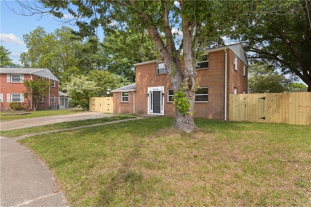 view of front of home with a gate, brick siding, and driveway