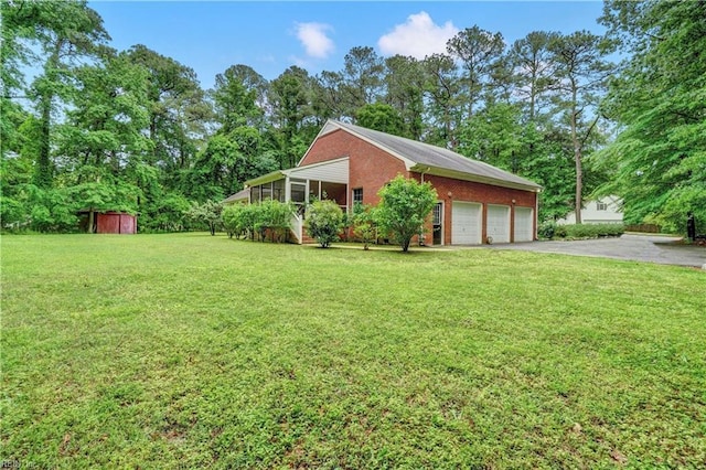 8 Pinckney Ln, Poquoson, VA 23662 - view of side of home featuring a storage unit, brick siding, asphalt driveway, a yard, and a sunroom