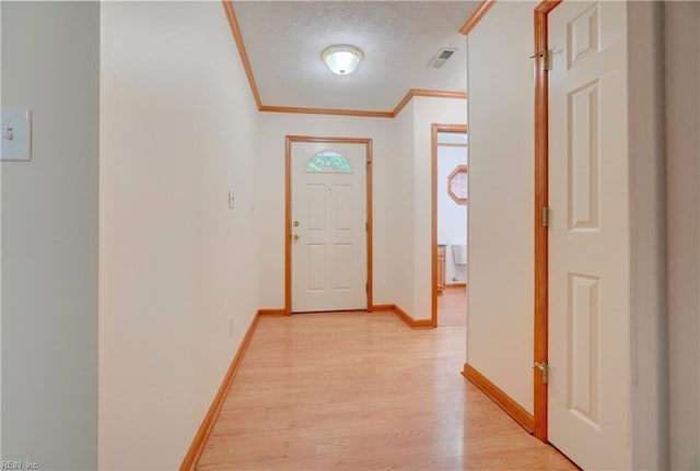8 Pinckney Ln, Poquoson, VA 23662 - doorway featuring light wood finished floors, baseboards, ornamental molding, and a textured ceiling
