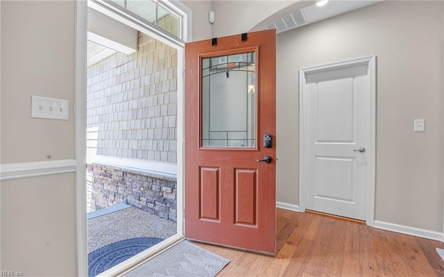 foyer entrance with wood finished floors, baseboards, and plenty of natural light