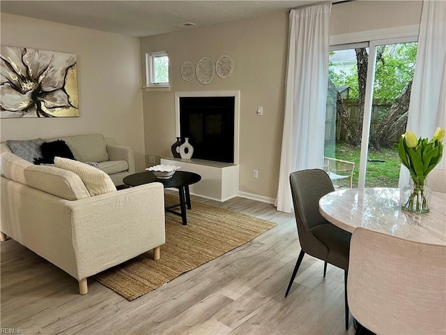 living area with light wood finished floors and baseboards
