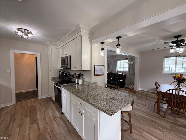 kitchen with appliances with stainless steel finishes, light wood-style flooring, and white cabinetry