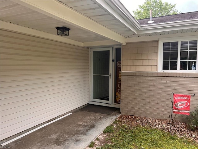 property entrance featuring brick siding