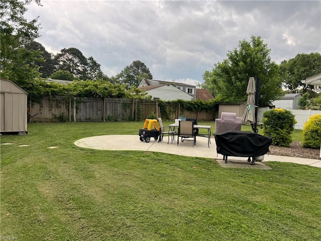 view of yard featuring a storage shed, a patio, and an outbuilding