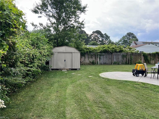 view of yard featuring a patio, a shed, and an outbuilding