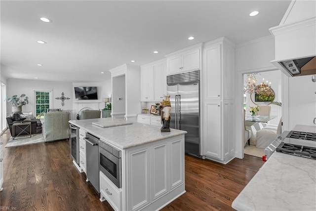2900 Thomas Smith Ln, Williamsburg, VA 23185 - kitchen with built in appliances, custom exhaust hood, white cabinetry, open floor plan, and crown molding