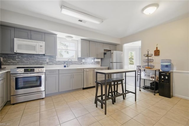 2809 Cedar Cove Ln, Chesapeake, VA 23323 - kitchen with appliances with stainless steel finishes, gray cabinetry, backsplash, light countertops, and light tile patterned floors