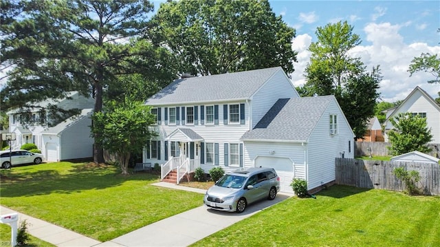 colonial inspired home featuring a garage, driveway, and roof with shingles