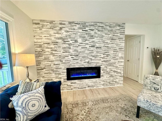 living room with wood finished floors, a fireplace, and baseboards