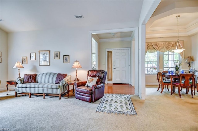 living area featuring light colored carpet, ornamental molding, and baseboards