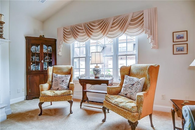 living area featuring carpet flooring, lofted ceiling, and baseboards