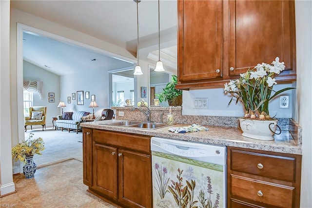 kitchen featuring white dishwasher, a sink, light carpet, decorative light fixtures, and brown cabinetry